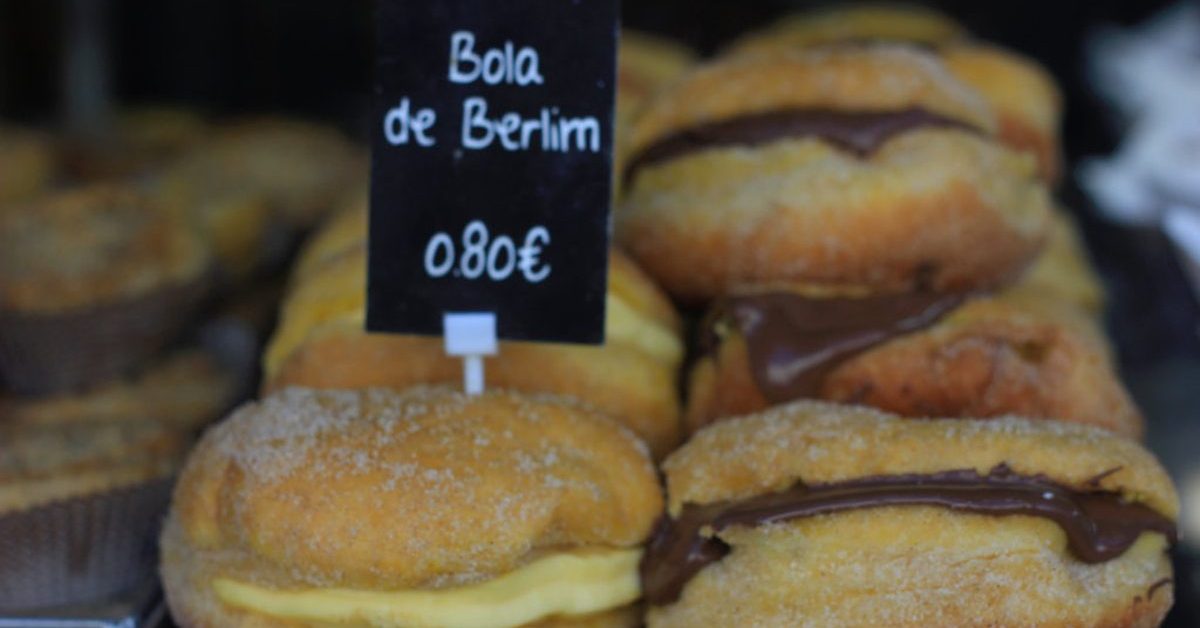 Bolas de Berlim fourrées à la crème dans une vitrine de pâtisserie portugaise