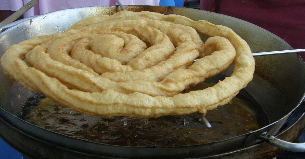 Fartura dorée sortant du bain de friture à la fête foraine