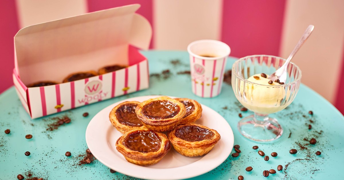 Pastéis de nata Wooly sur une assiette, à côté d'un café