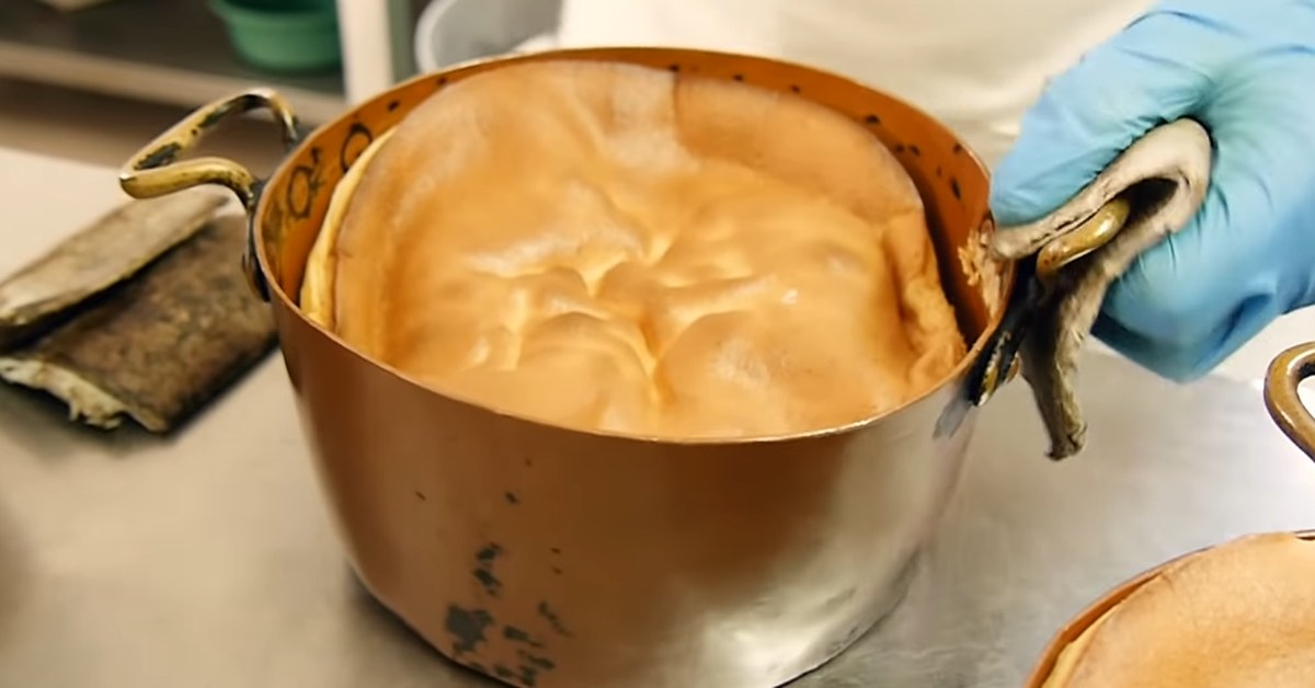 Un pão de ló de Alfeizerão sortant du four dans son moule en cuivre, chez un pâtissier portugais