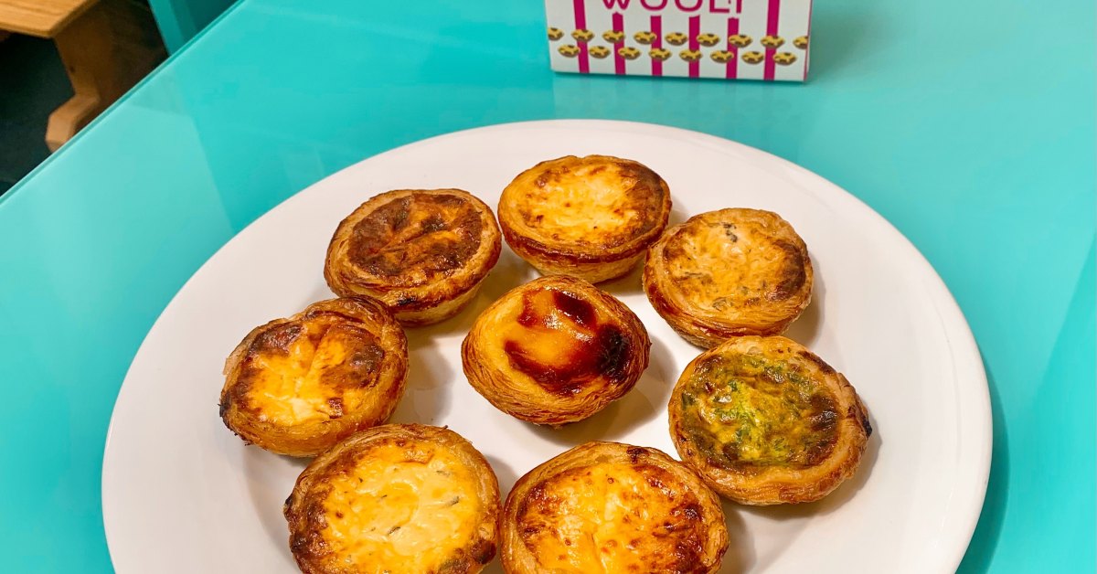 Recette des pastéis de nata : la traditionnelle, pas à pas Pastéis de nata Wooly dorés et tachetés de brun, sur une assiette blanche