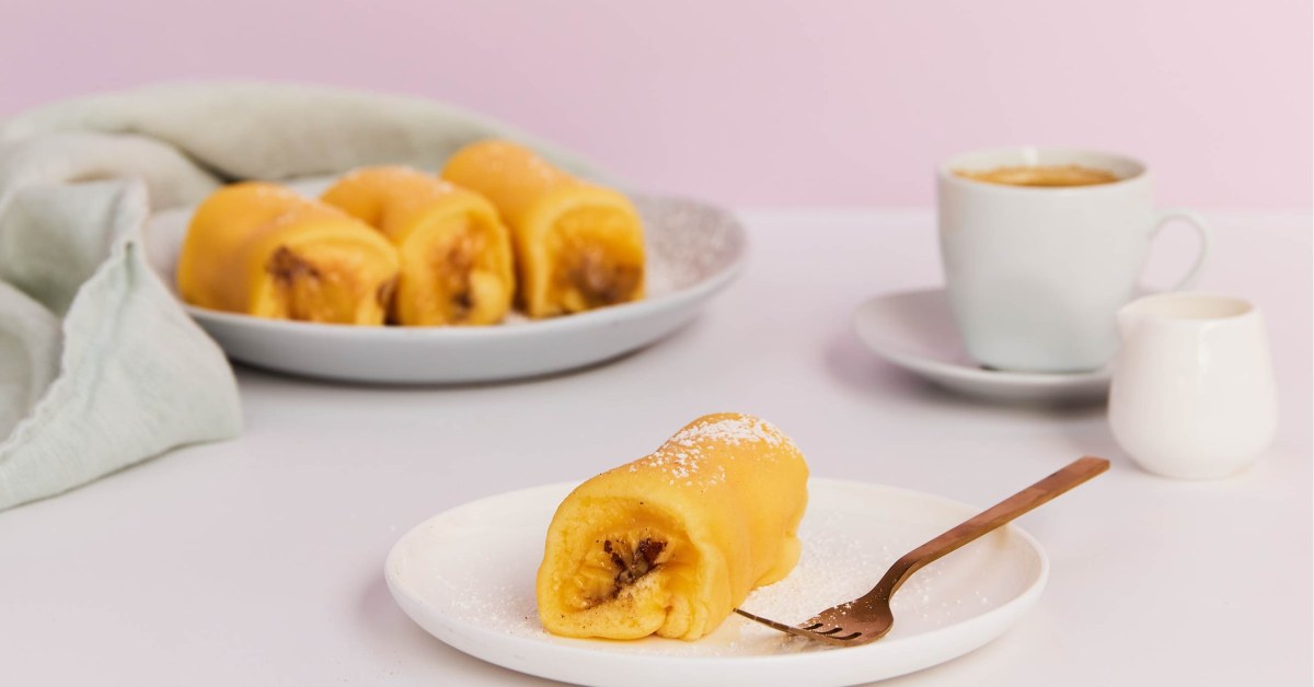 Tortas de Azeitão dorées sur une assiette, la crème d'œufs visible à l'extrémité du rouleau
