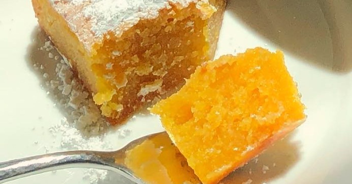 Part de toucinho do céu jaune saupoudrée de sucre glace, avec une bouchée sur une fourchette